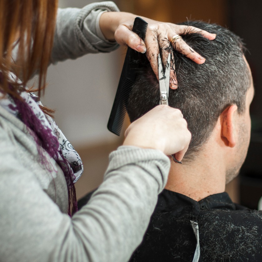 Peluquera cortando el pelo a hombre